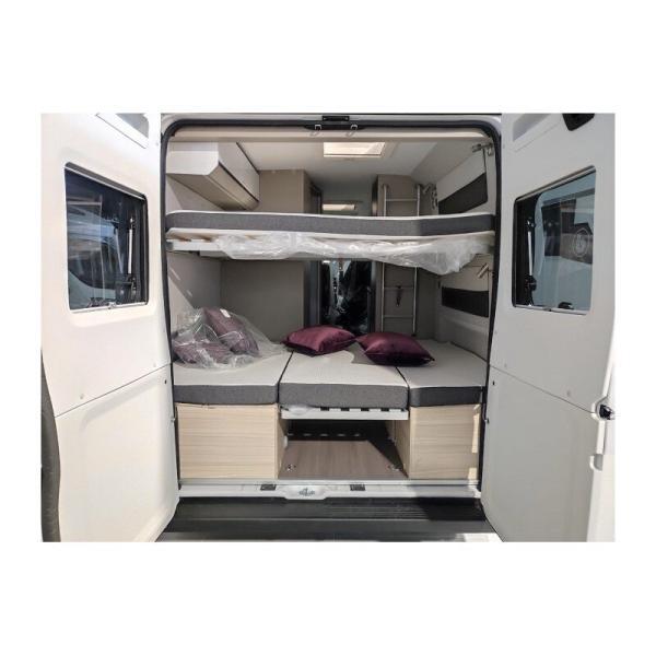 Puerta trasera abierta y camas literas montadas en el interior de la autocaravana Van Camper Adria Twin 600 SPB Family Plus