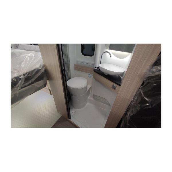 Acceso al baño con el lavabo y el váter en primer término de la autocaravana Adria Twin 640 SGX Plus