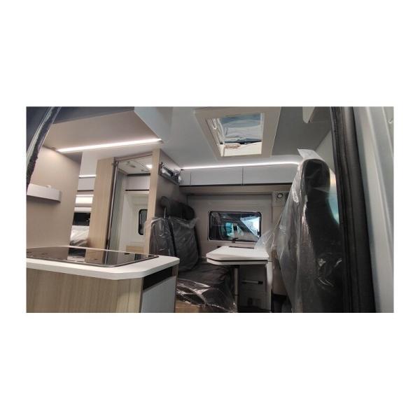 Vista del interior con mesa y asientos y barra de cocina de la autocaravana Adria Twin 640 SGX Plus